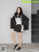 A woman in a black jacket and shorts posing for a picture.