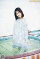 A woman in a polka dot dress standing in a pool.