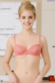 A woman in a pink bra posing in front of a whiteboard.