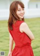 A woman in a red dress standing in a field.