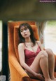 A woman in a red bathing suit sitting in a chair.