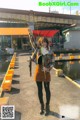 A woman holding up a fish while standing on a dock.