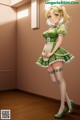 A woman in a green dress and white stockings standing in a room.