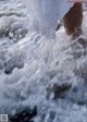 A woman in a white dress is standing in the water.