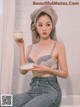 A woman sitting on a bathtub holding a bowl of cream.