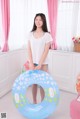 A woman standing next to an inflatable ring in a room.