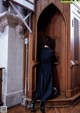 A woman in a blue dress is sitting in a wooden door.